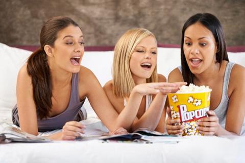 Three people eating popcorn.